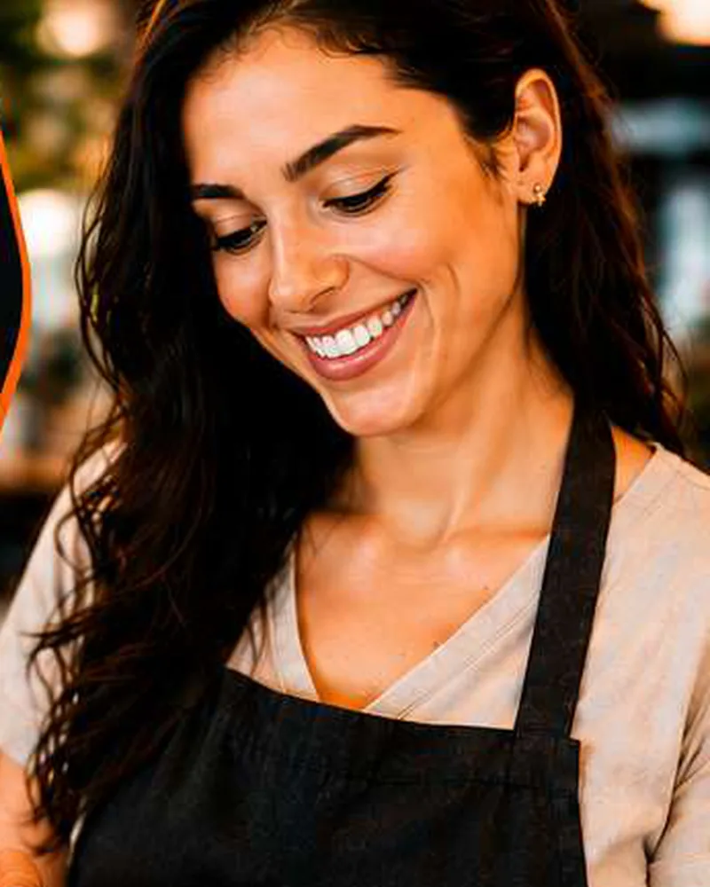 Atendente sorrindo passa um cartão na maquininha